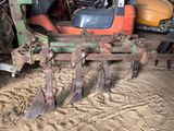 a tractor with a plow attached to it in the dirt