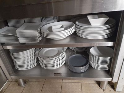 de nombreuses assiettes et bols empilés sur une étagère en métal