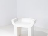 Le petit banc blanc se trouve dans un coin de la pièce.