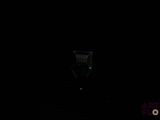 a cat that is sitting on a chair in the dark