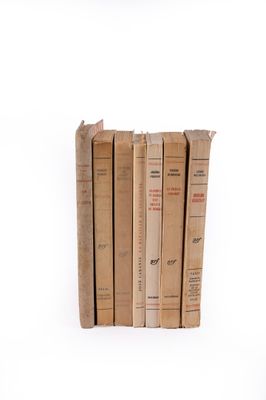 plusieurs vieux livres sont empilés sur une surface blanche