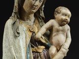 an old statue of a woman holding a baby and wearing a crown