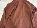 the north face brown flee jacket on a table with a pair of scissors