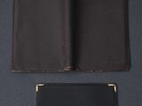 two leather wallets on a blue surface with one open and one closed