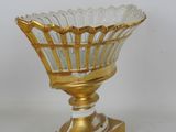 an image of a gold and white glass bowl on a stand