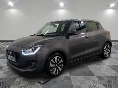 a grey suzuki swift is parked on a checkered floor