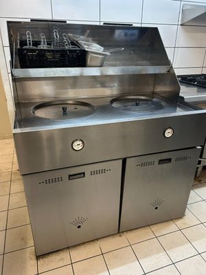 a stainless steel kitchen with two sinks and a stove
