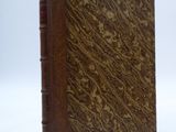 an old book sitting on top of a white surface with a white background