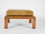an upholstered foot stool with a leather cushion on it