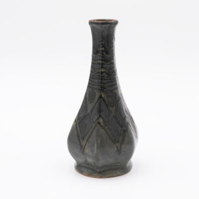 a black vase that is sitting on a white surface