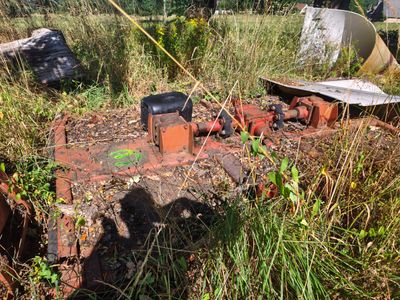 an old rusted engine sitting in the middle of a field