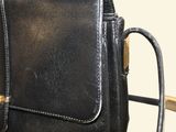 a black purse that is sitting on top of a chair