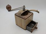 an old coffee grinder sitting on a white surface