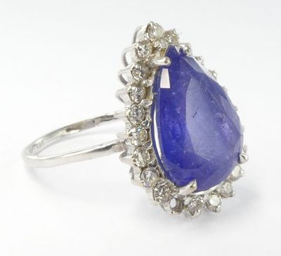 a close up of a tanzanite and diamond ring on a white background