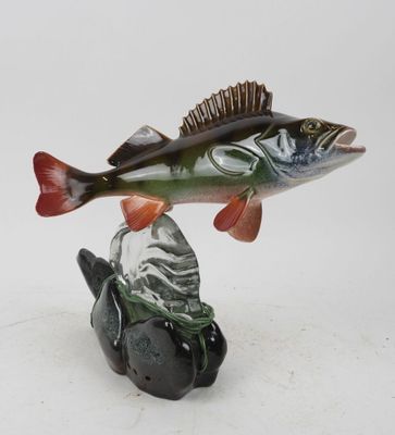 a figurine of a fish that is sitting on a rock