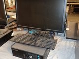 un ordinateur posé sur une table, avec un clavier et un écran