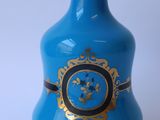 un vase bleu orné d'une décoration dorée