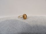 a close up of a gold ring on a white surface