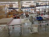 many tables and chairs in a warehouse with boxes on them
