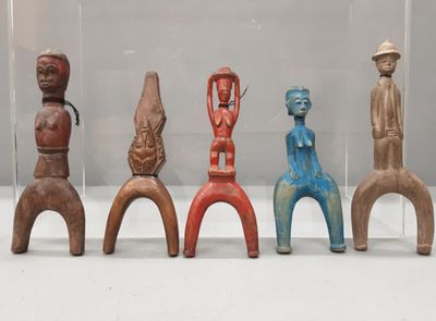 plusieurs figurines en bois de formes et de tailles variées, exposées dans une vitrine