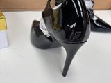 pair of black high heeled shoes sitting on a table next to a cardboard box