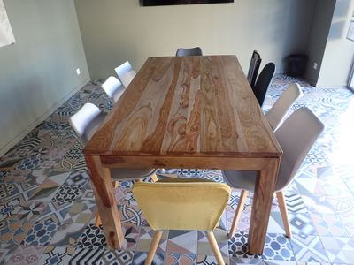 a wooden table with chairs and a painting on the wall