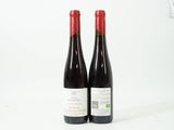 deux bouteilles de vin rouge posées l'une à côté de l'autre sur une surface blanche