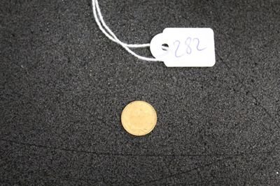 une pièce de monnaie posée par terre à côté d'un bout de papier