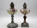 une paire de lampes anciennes en verre posées sur un pied en métal