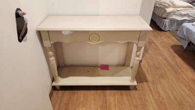a small white table with a drawer on top of it