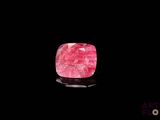 un gros plan d'une pierre rose sur une surface noire