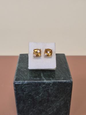 un gros plan sur une paire de boucles d'oreilles posées sur un bloc de marbre