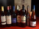 bottles of wine are lined up on a table in front of a box