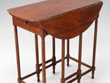 an antique mahogany drop leaf table with turned legs