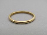 gros plan d'une bague en or sur une surface grise