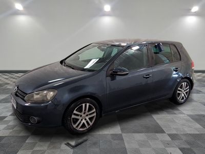 La Volkswagen Golf est garée dans un garage dont le sol est à damier.