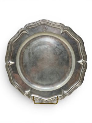 an antique silver plate with a gold handle on a white background