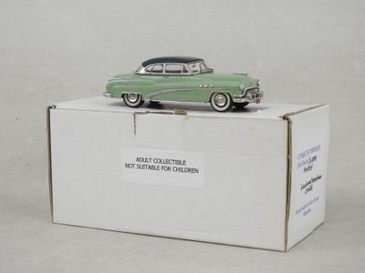 une petite voiture verte posée sur une boîte