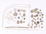a lot of silver jewelry on a white surface