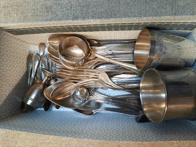 une boîte contenant tout un tas de cuillères en argent et d'autres cuillères