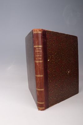 un vieux livre posé sur une table blanche à côté d'un mur gris