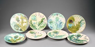 six assiettes ornées de motifs verts et blancs sur un fond gris