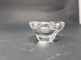 a small glass bowl on a table with a black background