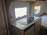 a small kitchen with a sink and a bed in it