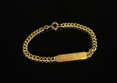 a close up of a gold bracelet with a bar on it