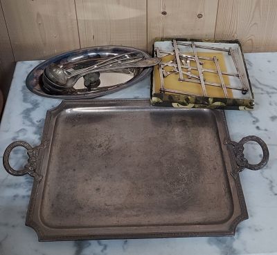 un plateau en argent posé sur une table en marbre, sur lequel se trouvent des couverts