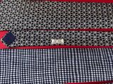several ties laid out on a red surface with a black and white checkered pattern