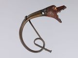 an image of a metal sculpture of a bird with a long tail