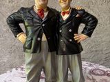 deux figurines représentant deux hommes debout l'un à côté de l'autre