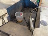a bucket of liquid sitting on the floor next to a metal container